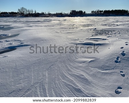 white snow drifts from the wind on the ice of the Volga River