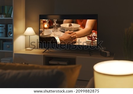 Romantic comedy movie streaming on TV and living room interior Royalty-Free Stock Photo #2099882875