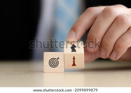 Business goals and strategies concept.  Game changer  for business adaptation and growth. Hand flips wooden cubes  with strategy to another strategy standing with  goal on smart background.