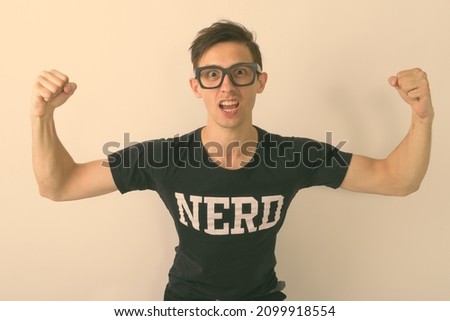 Studio shot of young handsome man as nerd against white background
