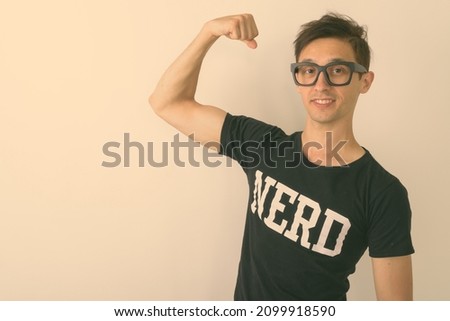 Studio shot of young handsome man as nerd against white background