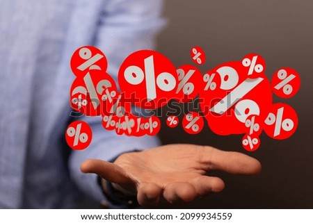 A closeup of the hand holding the floating percentage signs 
