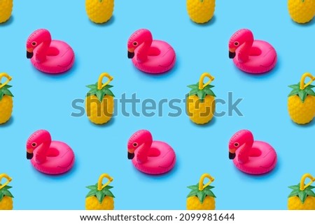 Summer pattern of toy pineapples and float flamingo inflatable toy on bright blue background