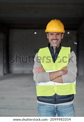 Vertical portrait of caucasian engineer standing on construction site Royalty-Free Stock Photo #2099983354