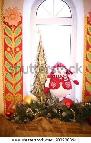 
a beautiful snowman in a red riding hood and a scarf and dumplings on the window