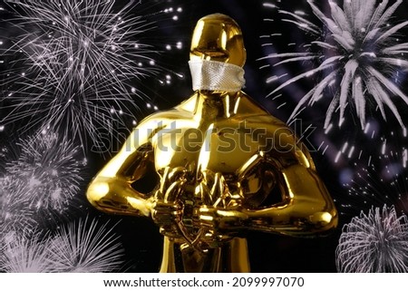 Hollywood Golden Oscar Academy award statue in medical mask on red background with copy space. Success and victory concept. Oscar ceremony in coronavirus time