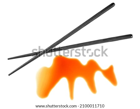 Splashes of soy sauce and wooden chopsticks isolated on a white background, top view. Japanese food.