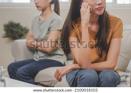 Unhappy lesbian, lgbt asian young two women, girl gay, couple love fight on sofa, relationship is in trouble. Different people are angry and use emotions at each other, expression of disappointmen. Royalty-Free Stock Photo #2100018103