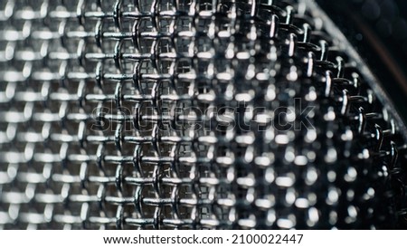Macro Shot of a Detailed and Reflective Metallic Pattern on a Microphone.