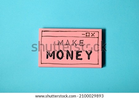 Making money online concept. Hand drawn web browser window with the text Make Money business memo on sticky note pile on blue paper background. 