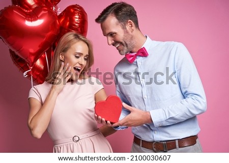 Caucasian ethnicity couple on pink background and  Valentine's Day gift