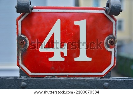 A red house number plaque, showing the number forty one (41)