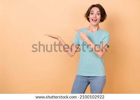 Photo of young girl excited indicate finger promo ads suggest recommend isolated over beige color background
