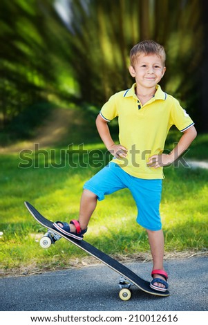 Little boy enjoying skateboarding in the park. 