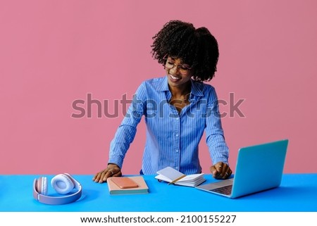 smiling young african american businesswoman looking down at workplace