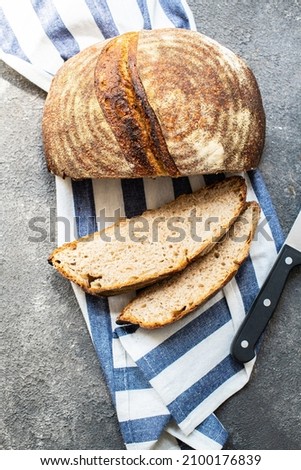 Sliced rye sourdough bread on a napkin, on a gray background. Artisanal bread concept. Overhead view.