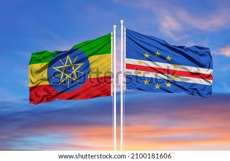 Ethiopia and Cape Verde two flags on flagpoles and blue cloudy sky  Royalty-Free Stock Photo #2100181606