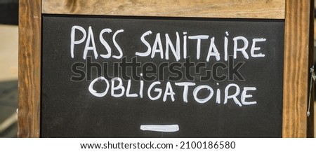 "sanitary pass required" written in French at the entrance of a restaurant during the Covid-19 pandemic in Paris, France