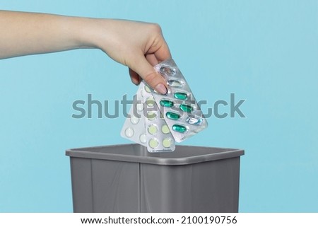 Throw the pills in the bin, pills in hand in front of the bin Royalty-Free Stock Photo #2100190756