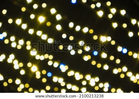 Background. Blurred Yellow Christmas lights on a black background. New Year's illumination. Concept of New Year celebration. Copy space for your design