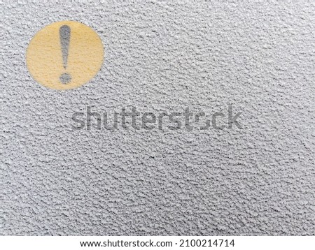 The yellow exclamation mark on the back window of the car covered by snow. Attention novice driver sign on the glass. Frozen window. Snow-covered car windshield. Close-up view. Royalty-Free Stock Photo #2100214714