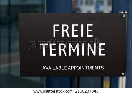 Sign with text freie Termine (German, translation is available appointments) outside an office building at City of Zürich on a cloudy winter day. Photo taken January 3rd, 2022, Zurich, Switzerland.