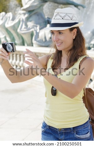 woman taking a picture with her camera in summer