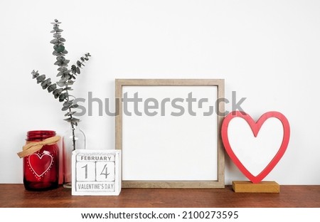 Mock up wood frame with Valentines Day heart decor and calendar. Wood shelf against a white wall. Copy space.