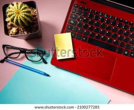 
workspace with red computer and plant