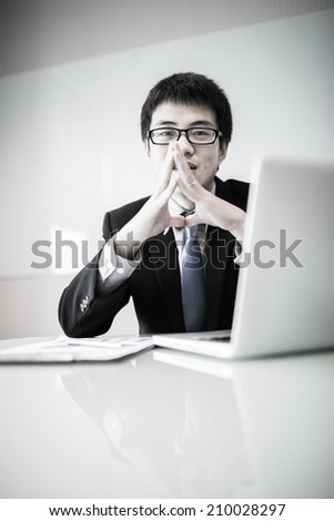 Young handsome man using laptop in his office.Asian