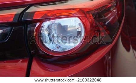 Red sports car tail lights Modern design provides light for safe driving, preventing accidents in traveling as a close-up view. Royalty-Free Stock Photo #2100322048