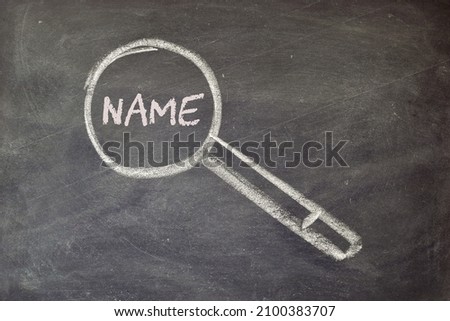 Concept of choosing a baby's name. Blackboard background with hand drawn magnifying glass.  Royalty-Free Stock Photo #2100383707