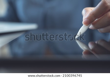 Close up of woman hand using stylus pen digital tablet, e-signing on screen, electronic signature concept.