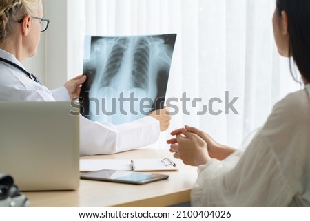 Caucasian woman doctor consulting to patient. Showing X-ray film and explaining the result of treatment.