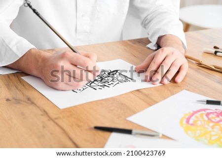 Male Arab calligraphist working in office, closeup Royalty-Free Stock Photo #2100423769
