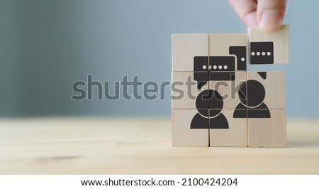 Consumer feedback concept.  Customer satisfaction evaluation to improve and develop product and service. Customer centric. Hand puts wooden cubes with "feedback" icon on grey background ,copy space. Royalty-Free Stock Photo #2100424204