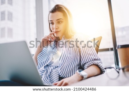 Caucasian female IT professional interested on received freelance task with program code, smart casual graphic designer working remotely on ideas for web project installing app for editing media