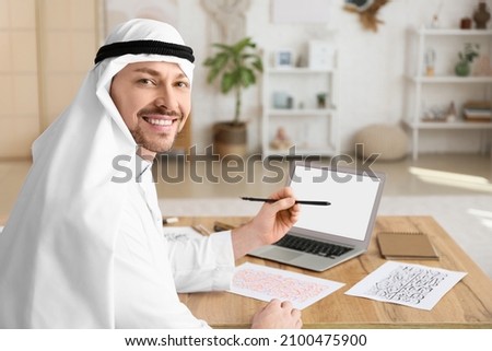 Male Arab calligraphist working in office