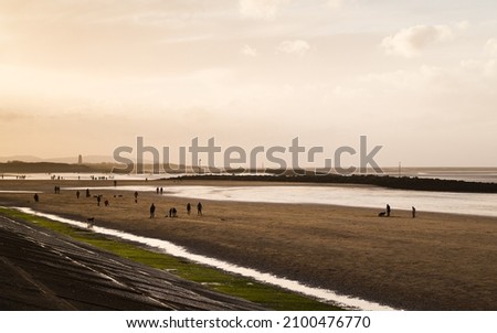 Leasowe Beach at low tide captured facing the late afternoon sunshine on 1 January 2022, silhouetting Leasowe Lighthouse in the distance.