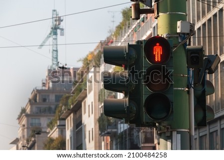 traffic light prohibiting the passage of pedestrians in the street of a large Italian city