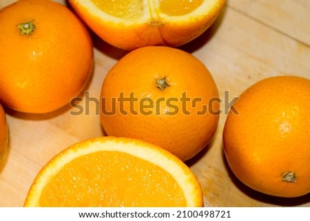 Tangerines and oranges, sliced ​​and whole on a board. Still life of bright fruits in orange and yellow