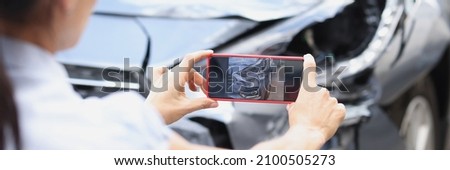 Insurance agent woman takes pictures by smartphone of car damage after road accident. Vehicle inspection and damage assessment concept