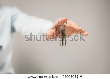 
a bunch of keys hanging on a finger. isolated focus