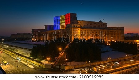 Palace of the Parliament building in Bucharest with the national flag of Romania projected on it Royalty-Free Stock Photo #2100515989