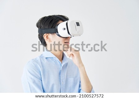 Asian man using the VR goggles Royalty-Free Stock Photo #2100527572