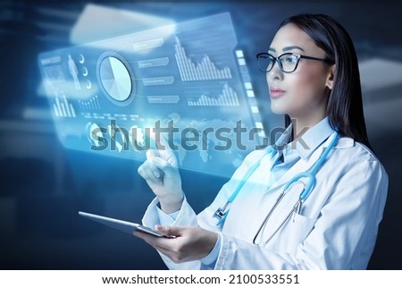 Female doctor holding a tablet computer and touching medical graphs on virtual screen. Medical innovative technology and network connection.