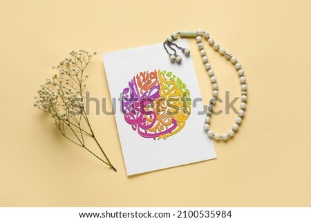 Paper with Arabic text, flowers and tasbih on color background
