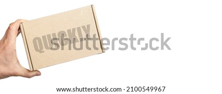 cardboard box in male hand. man holding a parcel. the inscription on the box quickly. the concept of sending parcels
