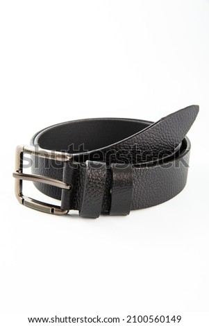 Fastened fashionable men's leather belt with dark matted metal buckle isolated on white background.