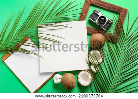 Composition with blank poster, clipboard, coconuts and photo camera on color background